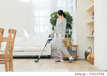 部屋で掃除機をかける女性 部屋で掃除機をかける女性 74115709