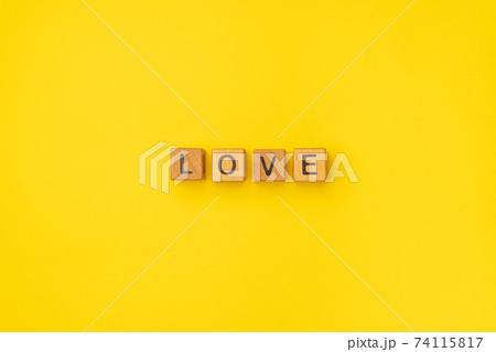 Wooden cubes with the word Love on an empty colorful yellow background. Word of love are made of Wooden cubes with the word Love on an empty colorful yellow background. Word of love are made of 74115817