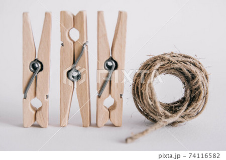 Wooden clothespins with rope on white background. Place for your text 74116582