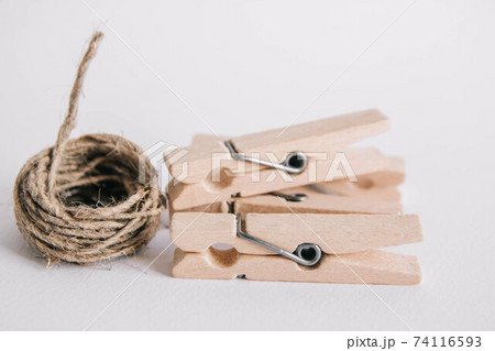 Wooden clothespins with rope on white background. Place for your text 74116593