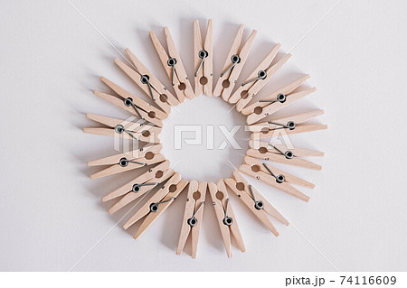 Group of wooden clothespins arranged in a circle isolated on white background. Copy space Group of wooden clothespins arranged in a circle isolated on white background. Copy space 74116609