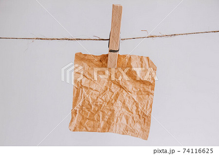 Brown stickers on clothesline with wooden clothespin isolated on white background. Place for your text Brown stickers on clothesline with wooden clothespin isolated on white background. Place for your text 74116625