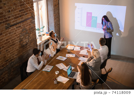 Female speaker giving presentation in hall at workshop. Audience or conference hall. Participants, co-workers listening at the table. Female speaker giving presentation in hall at workshop. Audience or conference hall. Participants, co-workers listening at the table. 74118009