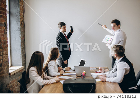 Male speaker giving presentation in hall at workshop. Audience or conference hall. Participants, co-workers listening at the table. Male speaker giving presentation in hall at workshop. Audience or conference hall. Participants, co-workers listening at the table. 74118212
