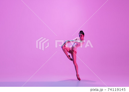 Young and graceful ballet dancer isolated on pink studio background in neon light. Art, motion, action, flexibility, inspiration concept. 74119145