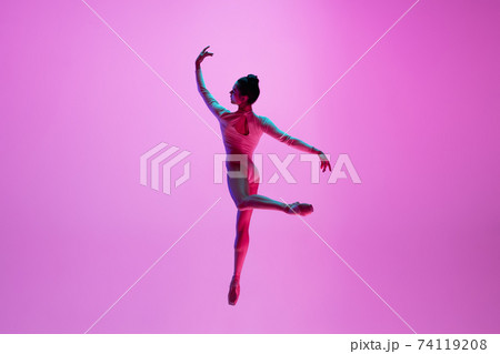 Young and graceful ballet dancer isolated on pink studio background in neon light. Art, motion, action, flexibility, inspiration concept. 74119208
