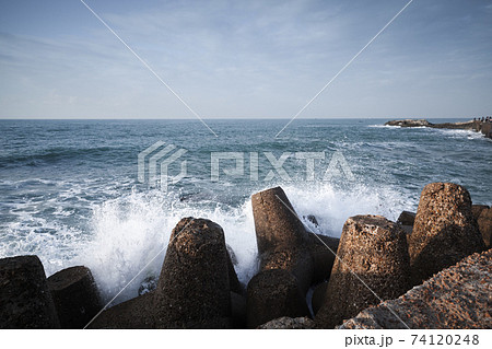 Concrete breakwater and splashing waves 74120248