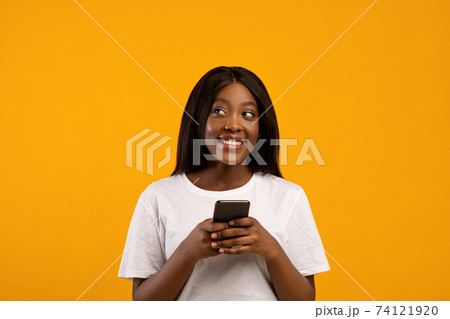 Smiling african american woman using mobile phone Smiling african american woman using mobile phone 74121920