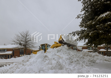 Snow plough truck clearing road after winter snowstorm for vehicle access Snow plough truck clearing road after winter snowstorm for vehicle access 74123251