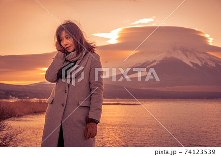 《山中湖》平野の浜から夕焼けの富士山を満喫する女性 74123539