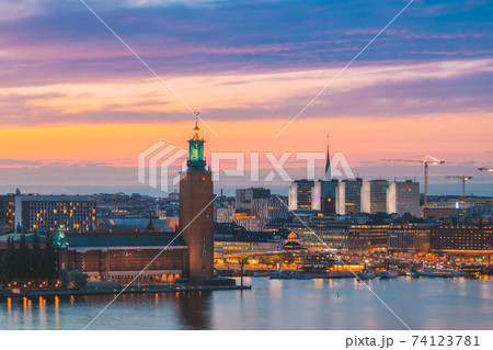 Stockholm, Sweden. Scenic Skyline View Of Famous Tower Of Stockholm City Hall And St. Clara Or Saint Klara Church. Popular Destination Scenic View In Sunset Twilight Dusk Lights. Evening Lighting Stockholm, Sweden. Scenic Skyline View Of Famous Tower Of Stockholm City Hall And St. Clara Or Saint Klara Church. Popular Destination Scenic View In Sunset Twilight Dusk Lights. Evening Lighting 74123781