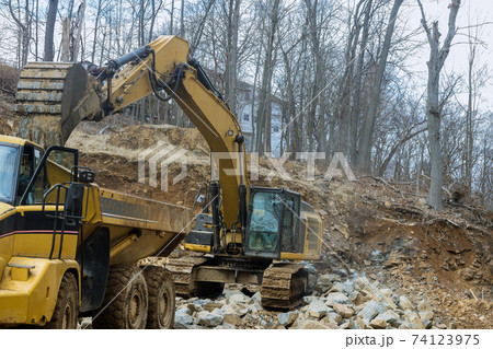 Loading bucket excavator a stones the excavator is loading excavation to dump truck. 74123975