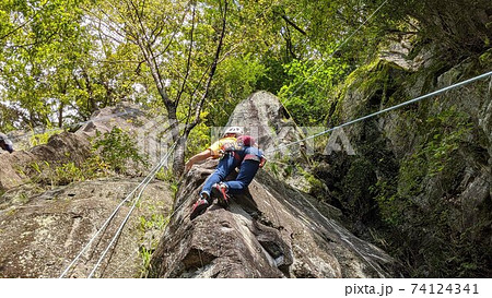 トップロープでロッククライミングをする女性の写真素材