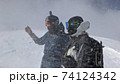 強風の雪山稜線上で状況を確かめているスノーボーダー 74124342
