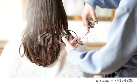 女性の髪をカットをする美容師の手元 74124800