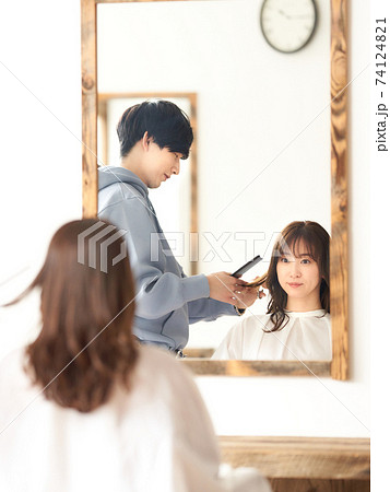 ヘアカットをしてもらう若い女性客 74124821