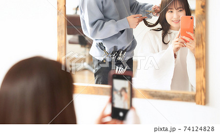 美容室にてスマホを手に持つ女性客 74124828