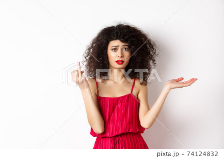 Sad girlfriend with curly hair, showing finger without ring and look confused, complaining at indecisive boyfriend, wanting to get married, standing on white background Sad girlfriend with curly hair, showing finger without ring and look confused, complaining at indecisive boyfriend, wanting to get married, standing on white background 74124832