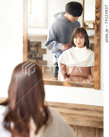 美容師と会話をする若い女性客の写真素材