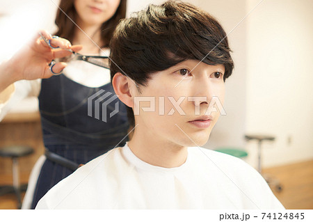 ヘアスタイリストに髪を切ってもらう男性客の写真素材