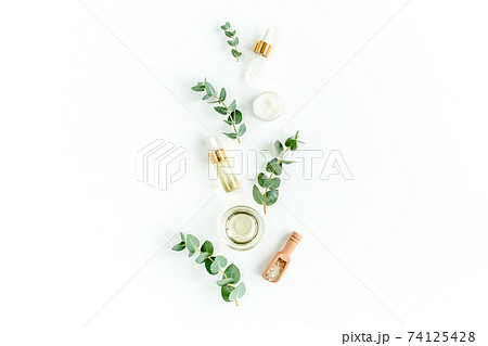 Eucalyptus essential oil, eucalyptus leaves on white background. Natural, Organic cosmetics products. Medicinal, Natural Serums. Flat lay, top view. Eucalyptus essential oil, eucalyptus leaves on white background. Natural, Organic cosmetics products. Medicinal, Natural Serums. Flat lay, top view. 74125428