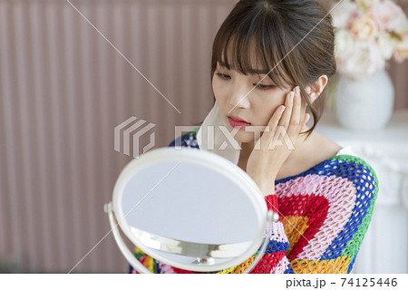 Young woman worrying about rough skin due to mask toothache Young woman worrying about rough skin due to mask toothache 74125446