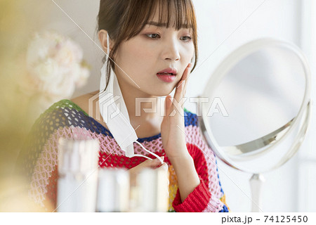 Young woman worrying about rough skin due to mask toothache Young woman worrying about rough skin due to mask toothache 74125450