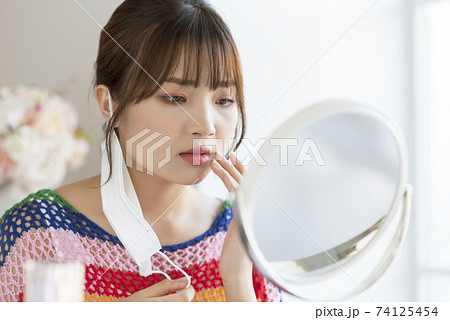 Young woman worrying about rough skin due to mask toothache Young woman worrying about rough skin due to mask toothache 74125454