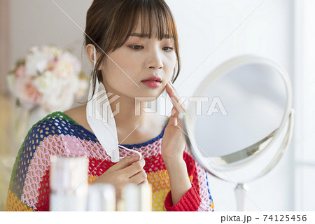 Young woman worrying about rough skin due to mask toothache Young woman worrying about rough skin due to mask toothache 74125456