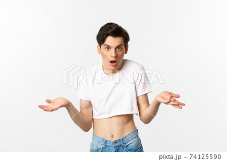 Lgbtq community. Confused gay man in crop top shrugging and staring at camera, cant understand, standing over white background 74125590