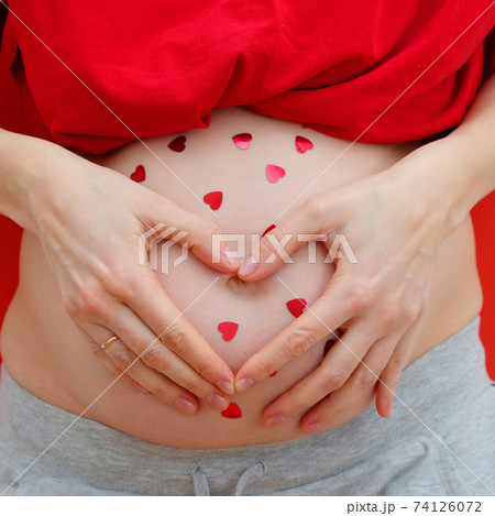 Pregnant Woman holding her hands in a heart shape on her baby bump. Maternity concept. 74126072
