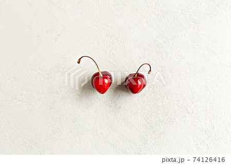 Pair of deformation ugly cherries in the heart shape flat lay on a white background. Zero waste concept. Imperfect, malformation berry 74126416