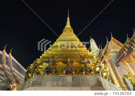 Giant guardian statue of Golden pagoda at Temple of the Emerald Buddha in Bangkok, Thailand. Wat Phra Kaew and Grand palace in old town, urban city. Buddhist temple, Thai architecture at night. Giant guardian statue of Golden pagoda at Temple of the Emerald Buddha in Bangkok, Thailand. Wat Phra Kaew and Grand palace in old town, urban city. Buddhist temple, Thai architecture at night. 74126703