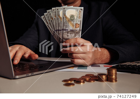 Businessman earn a lot of money from internet online by only using laptop. Investment concept 74127249