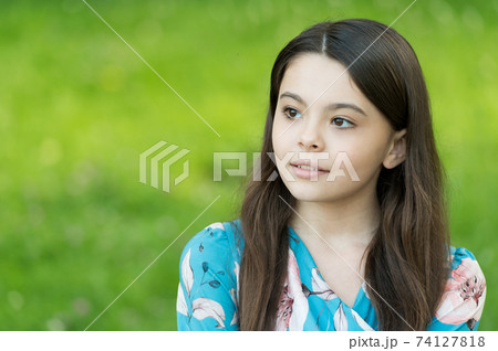 Little girl with long hair relaxing in park sunny day green Little girl with long hair relaxing in park sunny day green 74127818