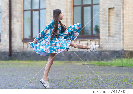 Girl summer dress flutters in motion urban background Girl summer dress flutters in motion urban background 74127819