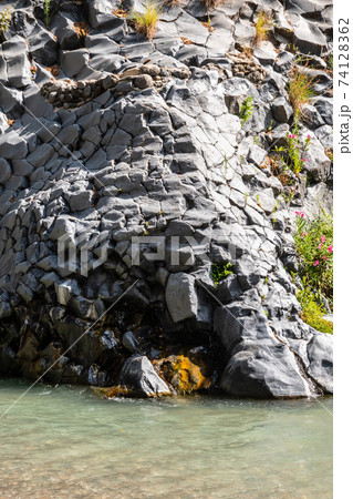 Basalt rocks and pristine water of Alcantara gorges in Sicily, Italy 74128362