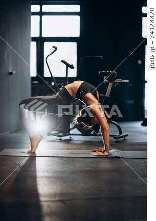Slim athletic woman doing exercise bridge at gym 74128820