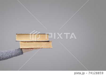 stack of old books in the palm of an invisible person 74128859