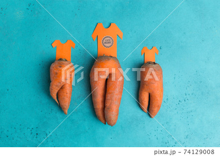 trendy ugly organic carrot as trousers with t-shirt cut from paper creative concept 74129008