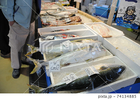 海鮮市場に並ぶ大きな魚とそれを見る人 74134885