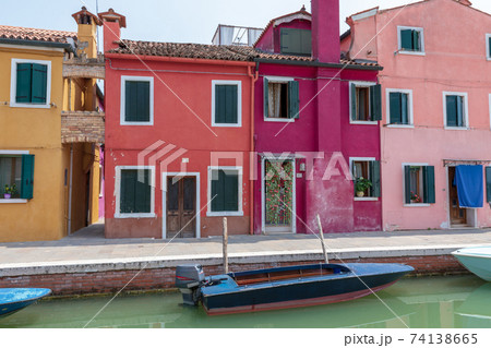 Panoramic view of coloured homes and water canal with boats in Burano Panoramic view of coloured homes and water canal with boats in Burano 74138665