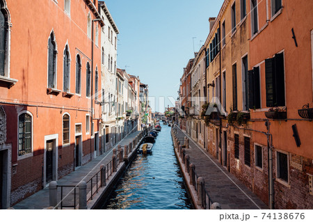 Panoramic view of Venice narrow canal with historical buildings and boat Panoramic view of Venice narrow canal with historical buildings and boat 74138676