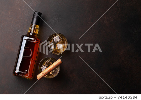 Scotch whiskey bottle, glasses and cigar 74140584