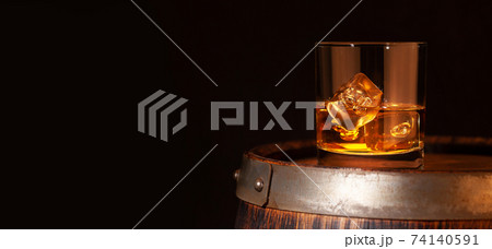 Scotch whiskey glass and old barrel 74140591