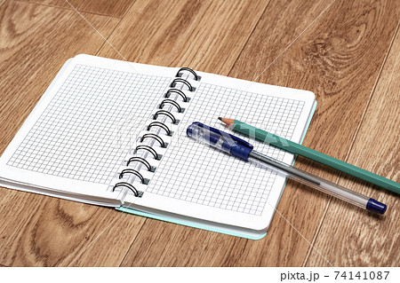 Open notebook, pen and pencil close up Open notebook, pen and pencil close up 74141087