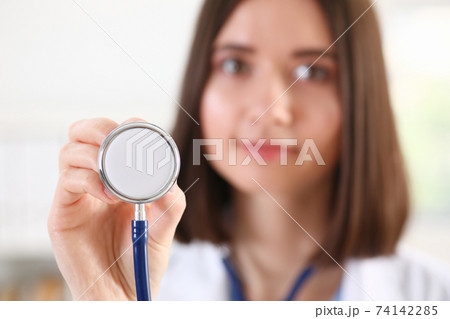 Female medicine doctor hand holding stethoscope head closeup Female medicine doctor hand holding stethoscope head closeup 74142285