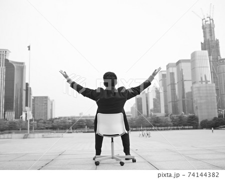 asian businessman opens arms embracing the city, black and white 74144382