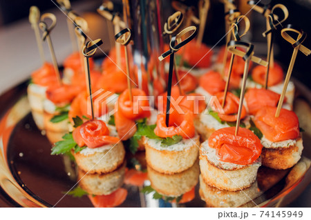 Canape, appetizers, on the table, buffet menu, European cuisine, shrimp, mini burger on a wooden background. 74145949