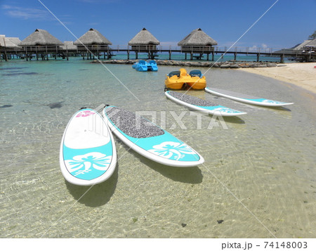 タヒチの浜辺に置かれたサーフボード 74148003